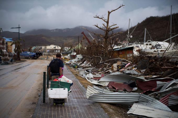 A sailor leaves with his belongings after loosing his boat in Marigot, on September 9, 2017 in Saint-Martin island devastated by Irma hurricane. Officials on the island of Guadeloupe, where French aid efforts are being coordinated, suspended boat crossings to the hardest-hit territories of St. Martin and St. Barts where 11 people have died. Two days after Hurricane Irma swept over the eastern Caribbean, killing at least 17 people and devastating thousands of homes, some islands braced for a second battering from Hurricane Jose this weekend. / AFP PHOTO / Martin BUREAU